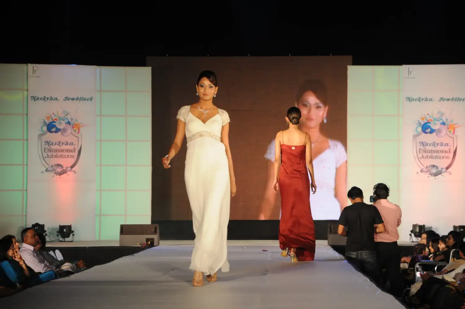 Group of men posing with large cartoon character inflatable figures at night outdoors